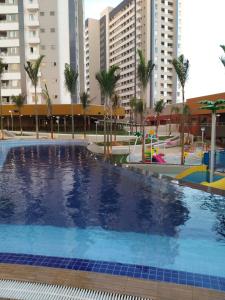 a large swimming pool with palm trees and buildings at APARTAMENTO OLIMPIA SOLAR DAS AGUAS in Olímpia