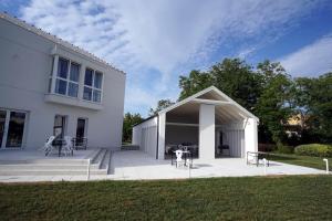 Casa blanca con patio con mesas y sillas en Dom wycieczkowy Zacisze en Sandomierz
