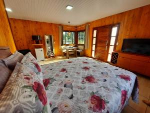 um quarto com uma cama com uma colcha florida em Cânions de Cambará em Cambará