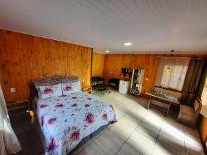um quarto com uma cama num quarto com paredes de madeira em Cânions de Cambará em Cambará