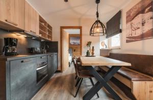 a kitchen with a wooden table and a dining room at Apartment Typ D im Alpin Resort Mo in Gargellen
