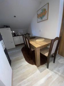 - une table à manger et des chaises dans la cuisine dans l'établissement Apartman FILIP, à Udbina