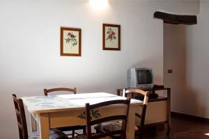 une salle à manger avec une table et une télévision dans l'établissement Il piccolo fienile, à Vessalico