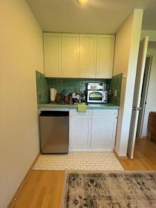 a small kitchen with white cabinets and a microwave at The Ocean Dunes at Amagansett in Amagansett