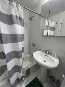 a bathroom with a sink and a shower curtain at The Ocean Dunes at Amagansett in Amagansett