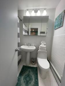 uma casa de banho com um lavatório, um WC e um espelho. em The Ocean Dunes at Amagansett em Amagansett