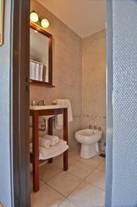 uma casa de banho com um lavatório e um WC em Rosario Suites em Rosário