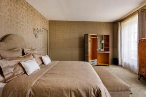 a bedroom with a large bed and a window at Le Château d Hardricourt in Hardricourt