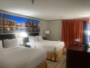 a hotel room with two beds and a window at Baymont by Wyndham Monterey Park in Monterey Park
