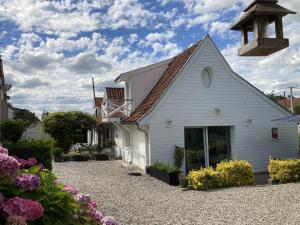 a white church with a cross on the roof at LE CHALET de LA LONGERE in Beuvry-Nord