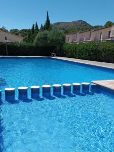 a swimming pool with blue water and stools in it at Villa L'Estartit in L'Estartit