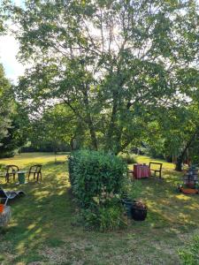 ein Park mit Bänken und ein Baum mit Tisch in der Unterkunft Chambre Matisse - Closeries du Golfe in Theix