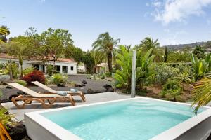 una piscina en un patio con un diván y una casa en Finca El Dragonal With Private Pool, en Santa Brígida