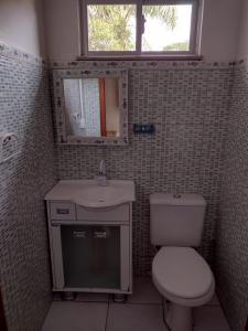 a bathroom with a toilet and a sink and a mirror at APARTAMENTO MARISCAL in Bombinhas