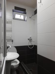 a bathroom with a toilet and a sink and a window at Kera Guest House in Kazbegi