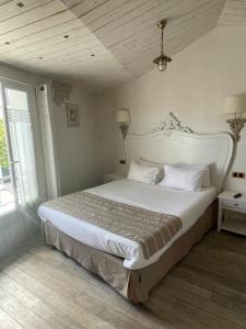 a bedroom with a large white bed and a window at Chambre d'hôtes Hôte des Portes Île de Ré in Les Portes