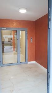 pusty pokój ze szklanymi drzwiami i pomarańczowymi ścianami w obiekcie Uroczy Apartament Happy 01 z widokowym tarasen na dachu - tuż przy plaży !!! w mieście Niechorze