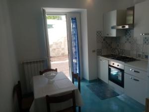 a kitchen with a table and a door to a patio at GRomano Apartments in Ischia Town