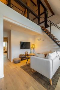 ein Wohnzimmer mit einer weißen Couch und einer Treppe in der Unterkunft Madrid Suites in Maastricht