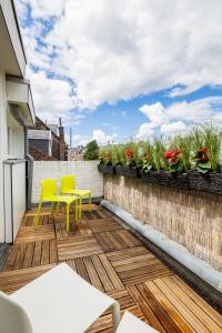 eine Terrasse mit gelben Stühlen und einem Zaun mit Blumen in der Unterkunft Madrid Suites in Maastricht