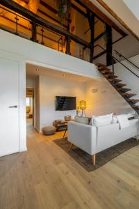 un soggiorno con divano bianco e scala di Madrid Suites a Maastricht