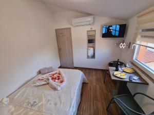 a bedroom with a bed and a table and a television at Hostel BellaVista in Koper