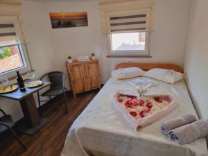 a bedroom with a bed with a heart shaped box on it at Hostel BellaVista in Koper
