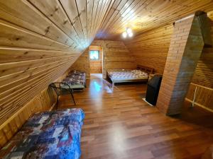 um quarto no sótão com 2 camas num chalé de madeira em Kalla Puhkemaja 