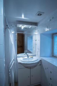 ein weißes Badezimmer mit einem Waschbecken und einem Spiegel in der Unterkunft Guyor in Le Bez