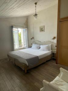 a bedroom with a large bed and a window at Chambre d'hôtes Hôte des Portes Île de Ré in Les Portes