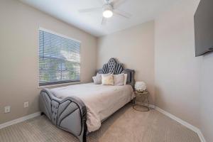 a bedroom with a bed with a blue headboard and a window at Vacation home with pool. 4 bedrooms. Sleeps 10 in Naples +41 photos