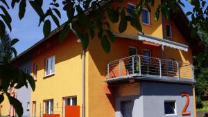 um edifício amarelo e laranja com uma varanda em Casa Philippi em Montabaur