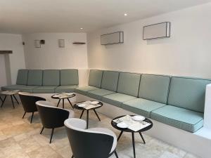 a waiting room with couches and tables and chairs at Chambre d'hôtes Hôte des Portes Île de Ré in Les Portes