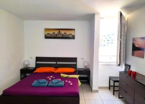 - une chambre avec un lit doté de draps violets et d'oreillers orange dans l'établissement El cortijo, pool view, à Playa de las Americas 13 autres photos