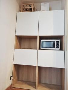 d'une armoire blanche avec un four micro-ondes. dans l'établissement Casa La Gardenia, à Torre del Lago Puccini