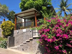 un conjunto de escaleras con flores delante de una casa en El Salvador Surf Houses, en Playa San Blas