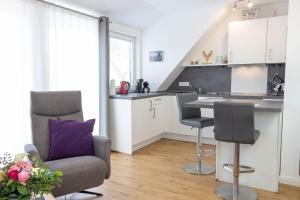uma cozinha com um sofá, uma cadeira e uma mesa em Heideträume Appartements em Undeloh