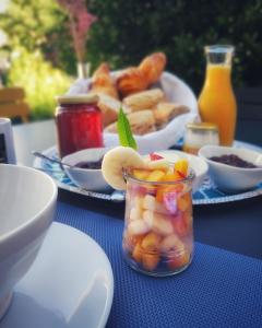 uma mesa azul com pratos de comida e um frasco de fruta em La Prévôté em Moissac