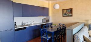 a kitchen with blue cabinets and a table with chairs at SKIPER VOIAGE in Savudrija