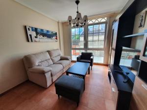uma sala de estar com um sofá e uma mesa em Apartamentos Nordés2 em Malpica de Bergantiños