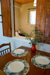 una mesa de madera con dos platos y un jarrón en ella en Kantounia Stonehouse en Vavkerí