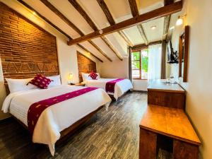 a hotel room with two beds and a window at Hotel Junvay in San Cristóbal de Las Casas
