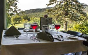 a table with glasses of red wine on top of it at Town & Country Inn & Resort in Gorham