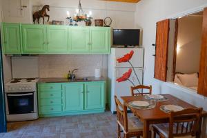 a kitchen with green cabinets and a table and a refrigerator at Kantounia Stonehouse in Vavkerí