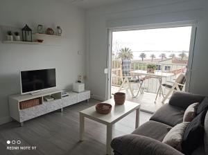 a living room with a couch and a tv at Apartamento acogedor en primera linea de playa in Denia