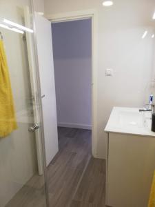 a bathroom with a sink and a glass shower door at Apartamento acogedor en primera linea de playa in Denia