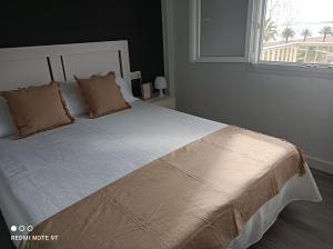 1 cama grande en un dormitorio con ventana en Apartamento acogedor en primera linea de playa, en Denia