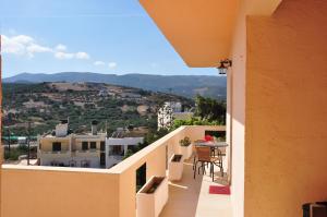 einen Balkon eines Hauses mit einem Tisch und Stühlen in der Unterkunft House Margot in Palekastro