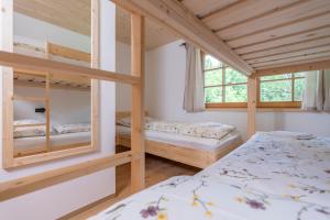 a bedroom with two bunk beds and a window at Planinska koča na Uskovnici in Srednja Vas v Bohinju