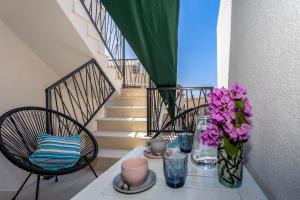 a table with a vase of flowers on a balcony at City Apartment Nora, old town located in Makarska